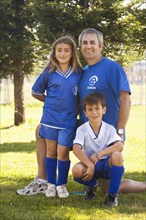 Father with children in soccer uniform