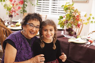 Hispanic grandmother and granddaughter at Thanksgiving dinner