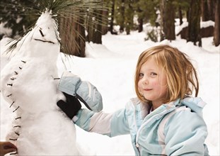 Caucasian girl making strange snowman
