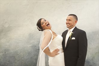 Hispanic bride and groom laughing