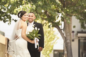 Smiling Hispanic bride and groom