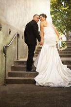 Hispanic bride and groom walking up steps