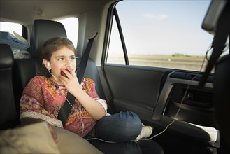 Mixed race girl eating apple in car