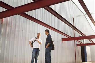 Men talking outside manufacturing plant