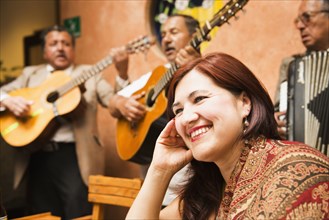 Hispanic woman in restaurant with traditional band