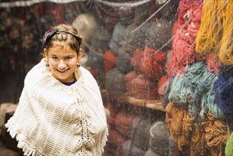 Hispanic girl wearing shawl in yarn store