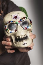 Hispanic artist holding Dia de los Muertos skull