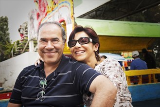 Hispanic couple smiling at amusement park