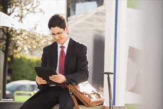 Hispanic businessman using tablet computer