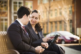 Hispanic business people using tablet computer