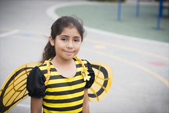 Portrait of Hispanic girl in bee costume
