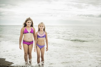 Girls smiling in waves on beach
