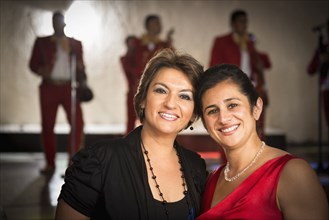 Hispanic women smiling at wedding reception