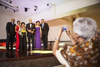 Hispanic family taking pictures at wedding reception