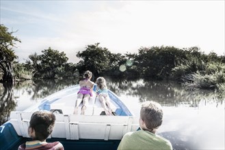 Children riding in canoe on rural lake