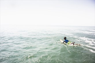 Caucasian boy surfing in ocean