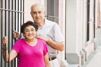 Older couple smiling together near gate