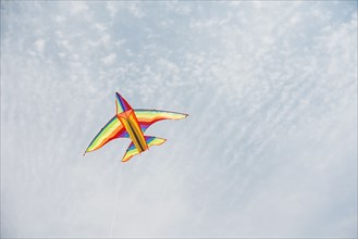 Colorful airplane kite flying in blue sky