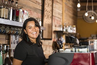 Smiling Hispanic woman working in coffee shop