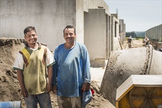 Hispanic construction workers smiling at construction site