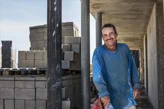 Hispanic construction worker smiling at construction site