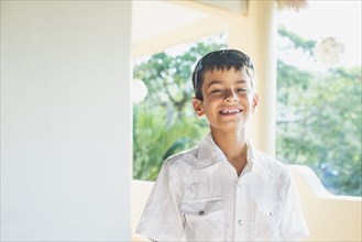 Mixed race boy smiling on porch