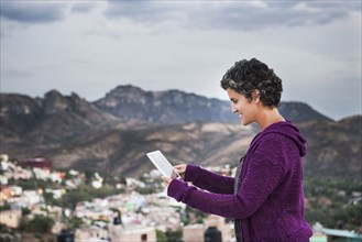 Caucasian woman using digital tablet on rooftop