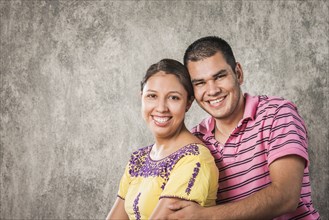 Smiling Hispanic couple hugging