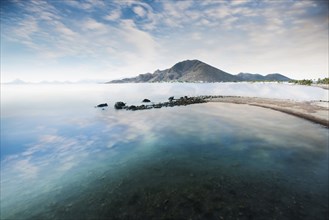 Cloudy blue sky reflecting in lake