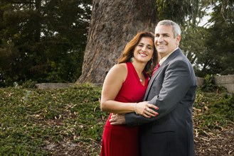 Smiling couple hugging in formal wear
