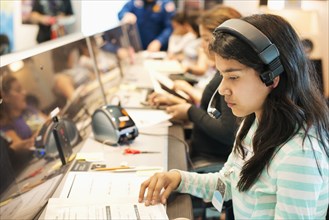Hispanic student listening to headset at desk