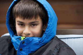 Close up of mixed race boy wearing parka and hood