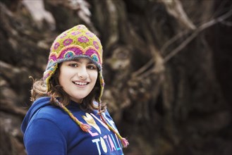 Mixed race girl wearing knit cap in forest
