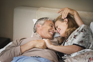 Laughing couple relaxing on bed