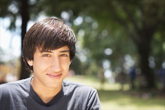 Hispanic teenage boy smiling in park