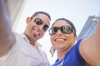 Low angle view of Hispanic couple wearing sunglasses