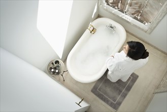 Woman having bubble bath in bathroom