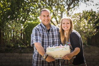 Couple holding cake at engagement party