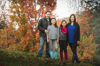 Family smiling on autumn hillside