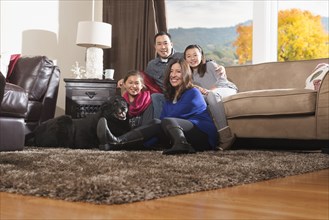 Family relaxing with dog in living room