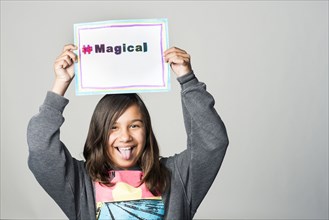 Hispanic girl holding magical sign above head
