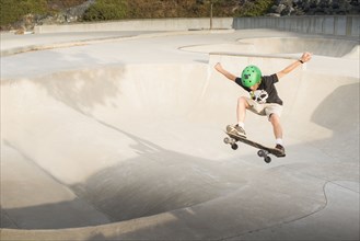 Mixed Race boy skateboarding in skate park