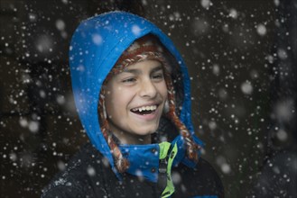 Mixed Race boy laughing in snow