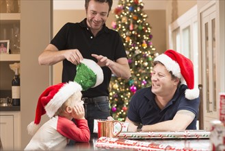 Caucasian fathers and son wearing santa hats