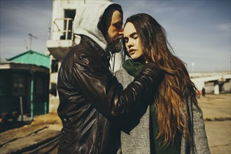 Caucasian man hugging woman outdoors