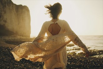 Wind blowing sweater of Caucasian woman at beach