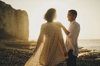 Caucasian couple on beach at sunset