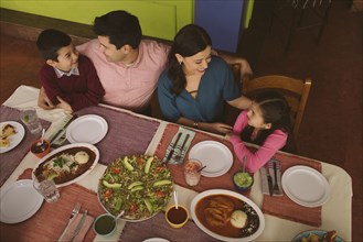 High angle view of Hispanic parents and children in restaurant