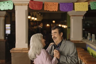 Older couple dancing in restaurant