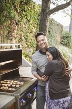 Expectant mother hugging husband near grille